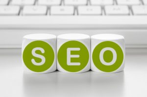 Letter dice in front of a keyboard - SEO