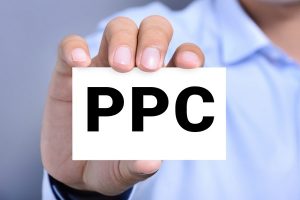 PPC (or Pay Per Click) sign on the card shown by a man