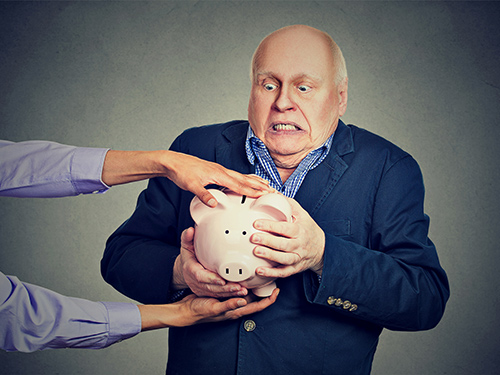 Picture of a guy holding on to his piggy bank