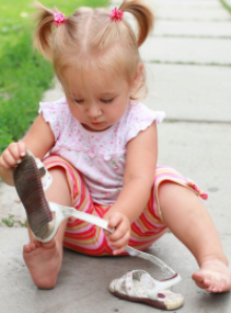 little girl playing with shoe