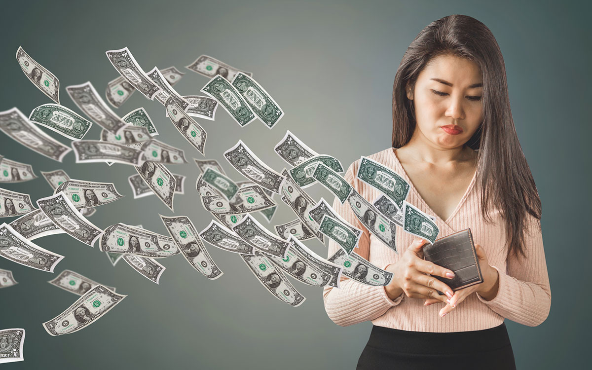Woman with her purse open and money flying out because of bad medical marketing services.